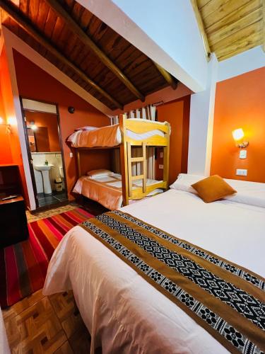 two beds in a room with orange walls at SARA GARDEN LODGE Ollantaytambo in Ollantaytambo