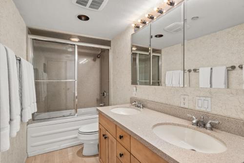 un bagno con due lavandini, un water e uno specchio di Chateau Eau Claire Unit 1, Stylish Condo Overlooking the River, Walking Distance to Downtown ad Aspen