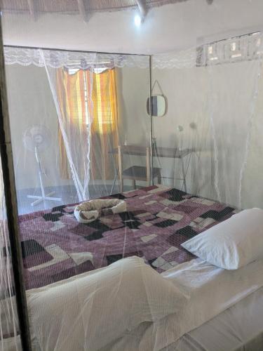 a bedroom with a bed with a quilt on it at Kulenga Village in Monkey Bay
