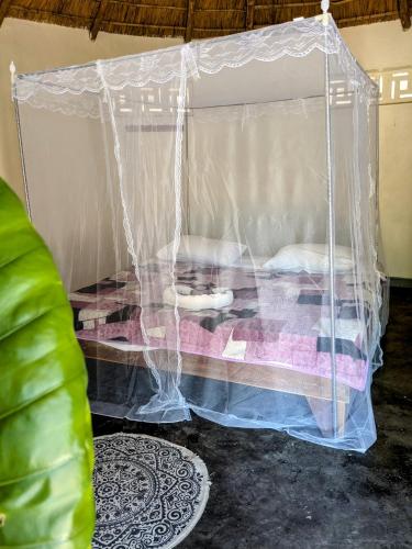 a bed in a plastic canopy in a room at Kulenga Village in Monkey Bay