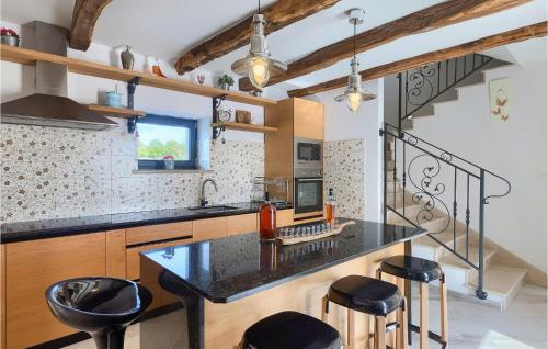 a kitchen with a black counter and some stools at Villa Simeanna in Kringa