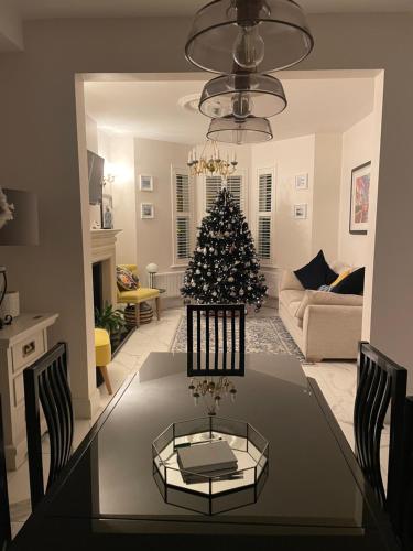 a dining table with a christmas tree in a living room at The White House in Newry