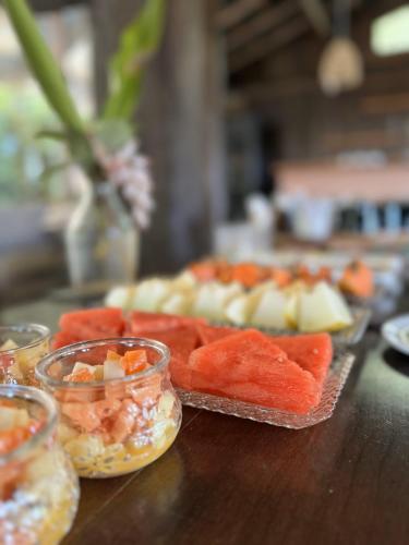 einen Tisch mit einem Tablett mit Essen auf dem Tisch in der Unterkunft Coração da Terra Praia do Rosa in Praia do Rosa