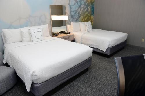a hotel room with two beds and a couch at Courtyard El Paso Airport in El Paso