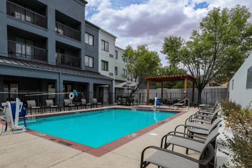 a swimming pool at a hotel with chairs around it at Courtyard El Paso Airport in El Paso