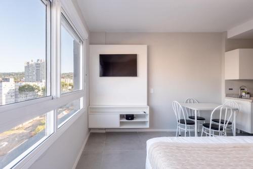 a bedroom with a bed and a table with chairs at Connect by LikeHome in Porto Alegre