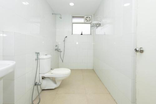 a white bathroom with a toilet and a shower at Raichak Green Villa by JadeCaps AC 3BHK Garden in Raichak