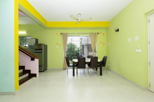 a dining room with a table and chairs at Raichak Green Villa by JadeCaps AC 3BHK Garden in Raichak