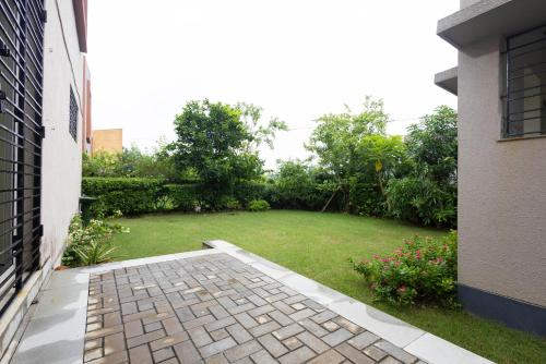 a backyard with a lawn and a yard with a house at Raichak Green Villa by JadeCaps AC 3BHK Garden in Raichak