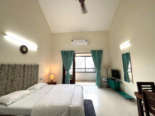a bedroom with a bed and a television in it at Riviera Sublime Holiday Homes in Siolim