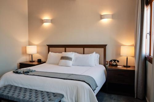 a bedroom with a large bed with two night stands and two lamps at Casa Lucila Mazatlán Curamoria Collection in Mazatlán