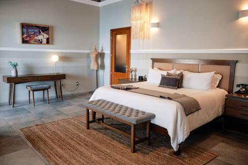 a bedroom with a large bed and a desk at Casa Lucila Mazatlán Curamoria Collection in Mazatlán
