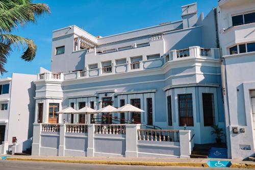 a large white building with umbrellas in front of it at Casa Lucila Mazatlán Curamoria Collection in Mazatlán