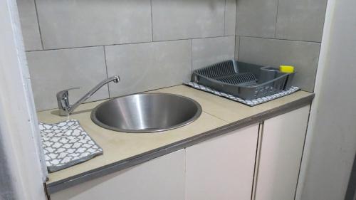 encimera de cocina con fregadero y colador en Kombi Cove, en Ciudad del Cabo