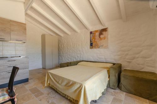 Pagliaio Tipico nello Junno في ماتيناتا: غرفة نوم فيها سرير واريكة