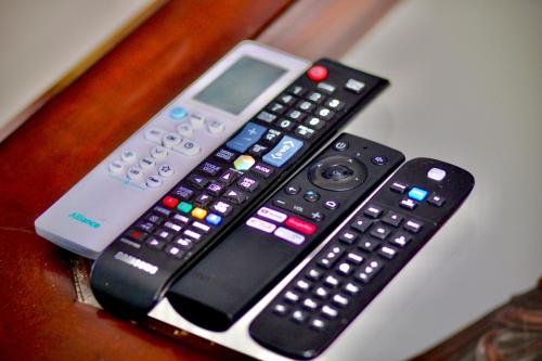 three remote controls sitting on top of a table at The Legacy BnB in East London