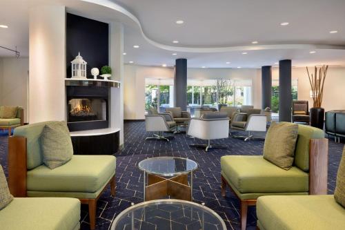 a waiting room with chairs and a fireplace at Courtyard Edison Woodbridge in Edison