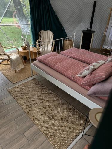 a bed with a metal frame in a room at The Frog Glamping in Horezu