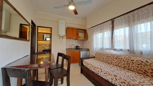 a living room with a couch and a table and a kitchen at Lomitas Villa Gesell in Villa Gesell