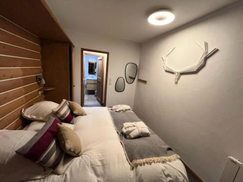 - une chambre avec 2 lits et un mur avec des bois dans l'établissement Résidence Les Arcs 1950 Le Village - maeva Home - Appartement charmant vue montagne 2 pièces 4 personnes - Prestige - super Home MAE-9531, à Arc 1950