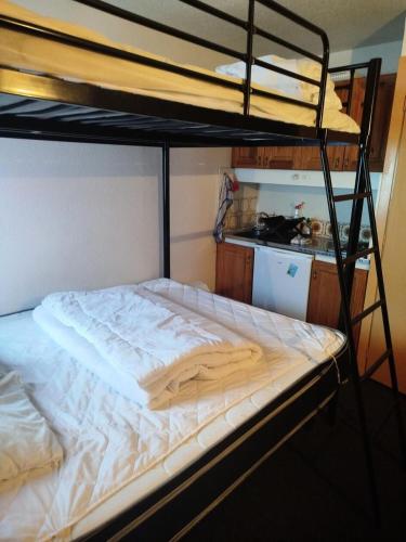 Ce lit superposé se trouve dans un dortoir doté d'une cuisine. dans l'établissement Résidence Le Tourmalet - maeva Home - Studio 4 personnes - Confort MAE-8121, à La Mongie