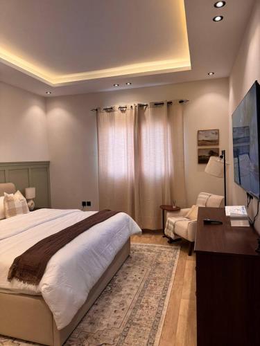 een slaapkamer met een groot bed en een woonkamer bij غرفة على الطراز الريفي in Riyad