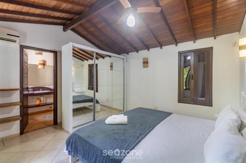 una camera da letto con un letto e una cabina doccia di Casa c/3 suítes a 400m da Praia do Mucugê MCG0006 a Arraial d'Ajuda