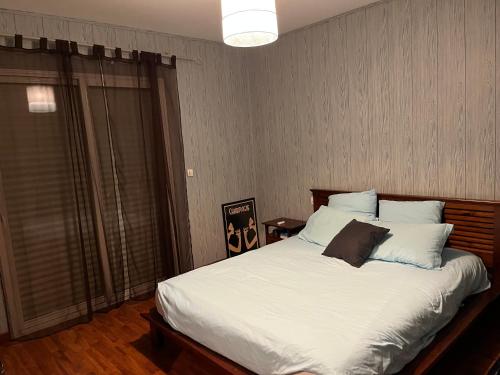 une chambre avec un lit avec des draps blancs et des oreillers dans l'établissement Villa 180m2 proche Lac Hourtin, à Hourtin