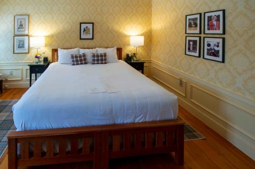 a large white bed in a room with pictures on the wall at Swift House Inn in Middlebury