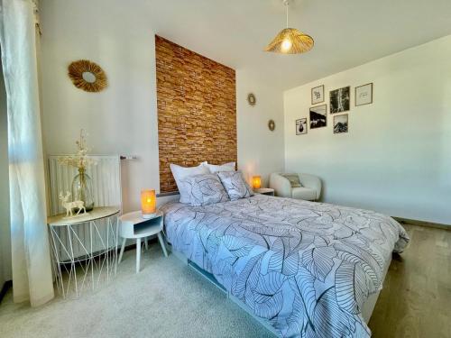 une chambre avec un lit et un mur de briques dans l'établissement Le Nid des Alpages, à Annecy