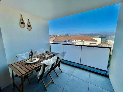 d'un balcon avec une table et des chaises en bois ainsi qu'une grande fenêtre. dans l'établissement Le Nid des Alpages, à Annecy