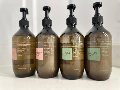 a group of four bottles with labels on them at CitySide Hotel Tauranga in Tauranga