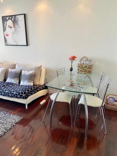 a living room with a glass table and a couch at Amazing Spacious Seaview Condo in North Pattaya