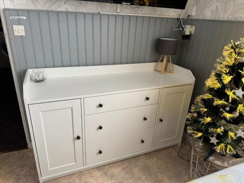 une commode blanche avec une lampe dessus dans l'établissement Appartement situé au cœur du village du Mont-Dore, à Le Mont-Dore