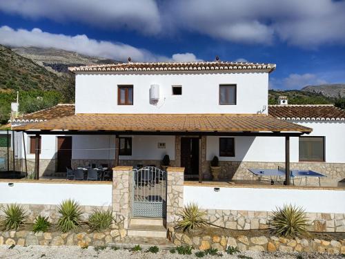 a white house with a roof at Casa La Fuente in El Chorro