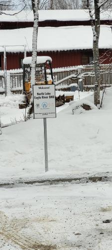 a sign in the snow in front of a building at North Lakes Eagle River B&B in Eagle River