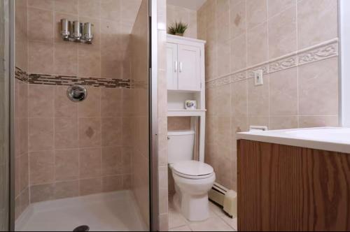 a bathroom with a shower and a toilet and a sink at City Gem in Long Island City