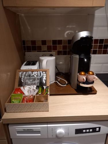 - un comptoir de cuisine avec une boîte de nourriture et une cafetière dans l'établissement Petit Prince Proche Roissy CDG, à Villeneuve-sous-Dammartin