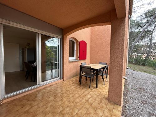 une terrasse avec une table et des chaises dans une maison dans l'établissement Appartement cote pinede 1 chambre, à Saint-Raphaël