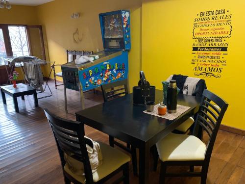 a dining room with a table and chairs and a yellow wall at Casa zona Estadio Único Fórum Terminal de omnibus Peatonales A Minutos del Nodo Tecnológico in Santiago del Estero