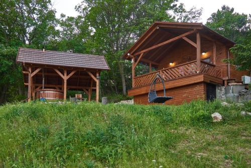 a large wooden cabin with a gazebo at Kisleshegy Vászoly Vendégház in Dörgicse