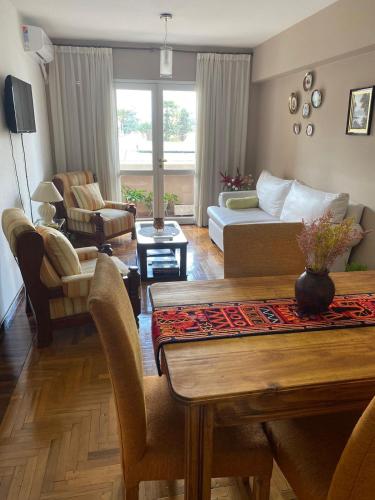 ein Wohnzimmer mit Tisch und Couch in der Unterkunft Departamento Pleno Centro Amplio y Cómodo in San Salvador de Jujuy