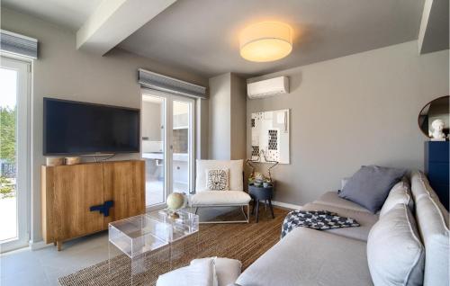 a living room with a couch and a tv at Villa Lunjsko in Stara Novalja