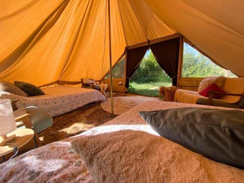 a tent with two beds and a chair in it at Organic Farmstay Glamping in St. Paul's Bay