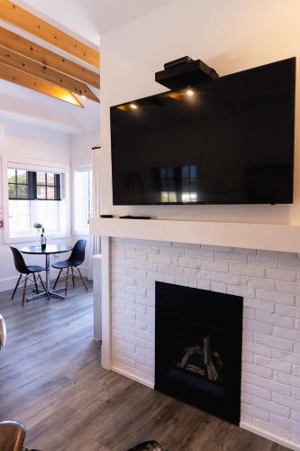 a living room with a fireplace with a tv above it at The VanderMarck Boutique Hotel in Collingwood