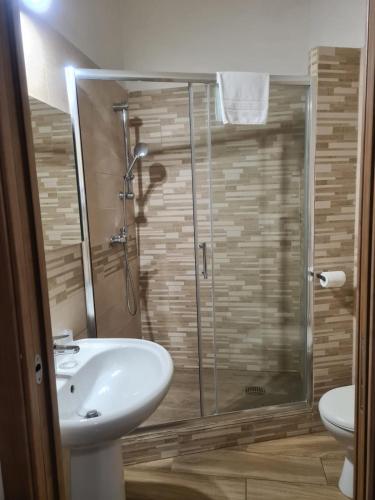 a bathroom with a sink and a glass shower at Lido Venere Affittacamere in Metaponto