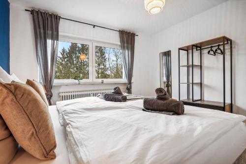 ザンクト・ヴェンデルにあるWendel Living I - Gemütlich und modernの大きな白いベッドとタオルが2枚置かれた寝室