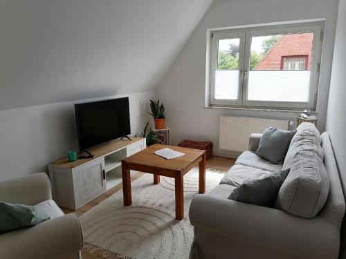 a living room with a couch and a tv at Hygge II in Friedrichstadt