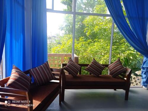 een kamer met een bank en een groot raam bij Dream Sun in Weligama