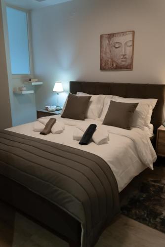 コニツァにあるCentral Square Residenceの大型ベッド1台(リモコン2台付)